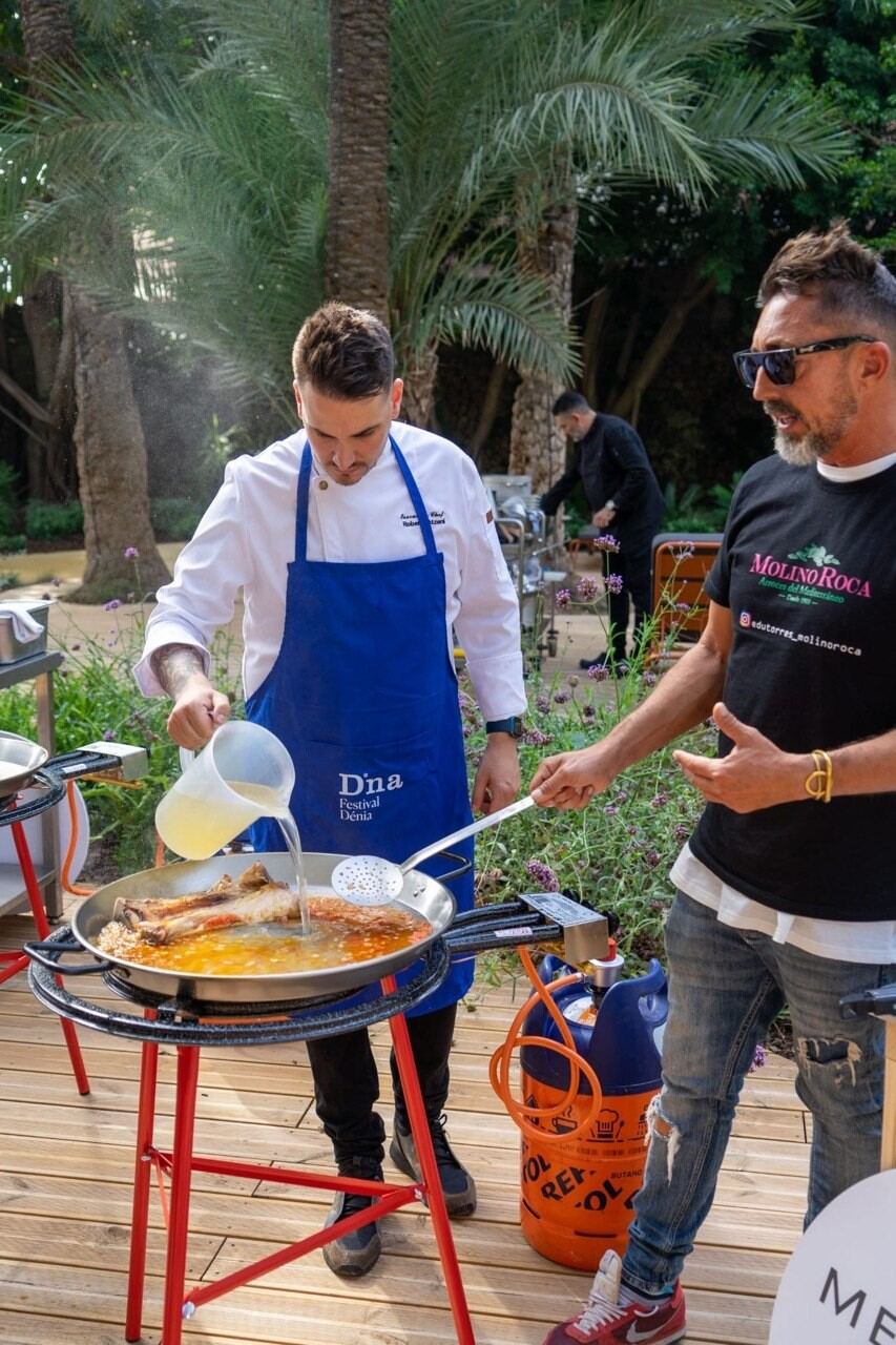 Chef sirviendo paella en cocina de evento