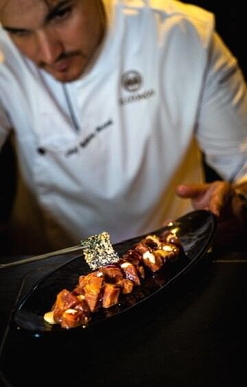 Chef presentando un plato en negro