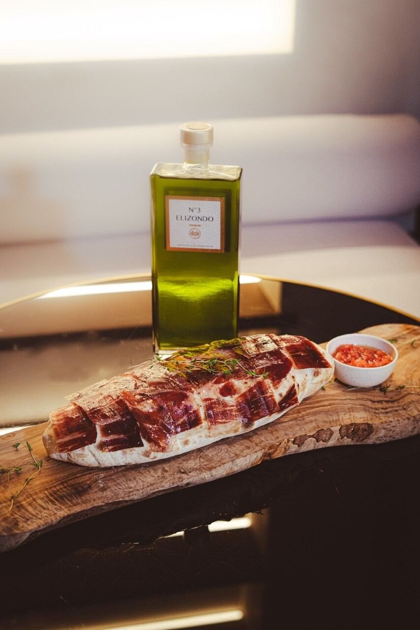 Aceite de oliva y jamón sobre tabla