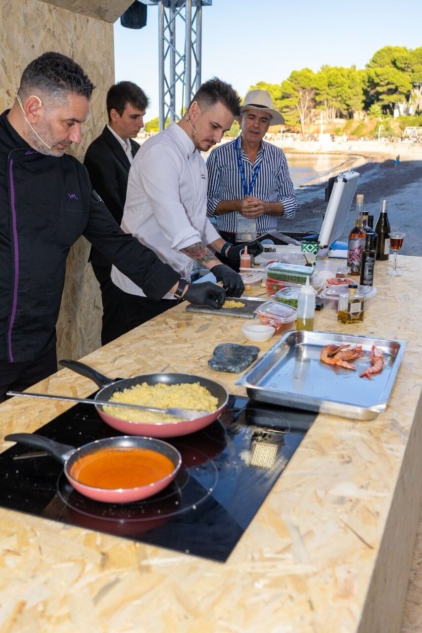 Grupo de chefs elaborando paella al aire libre