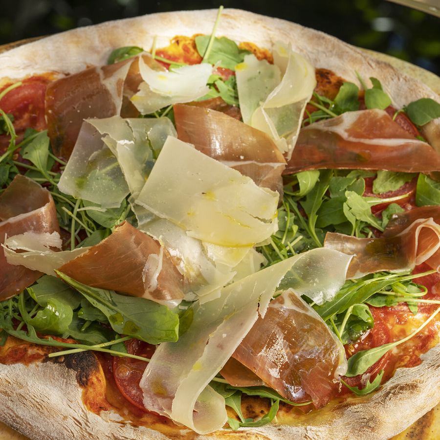 Pizza con jamón y virutas de parmesano