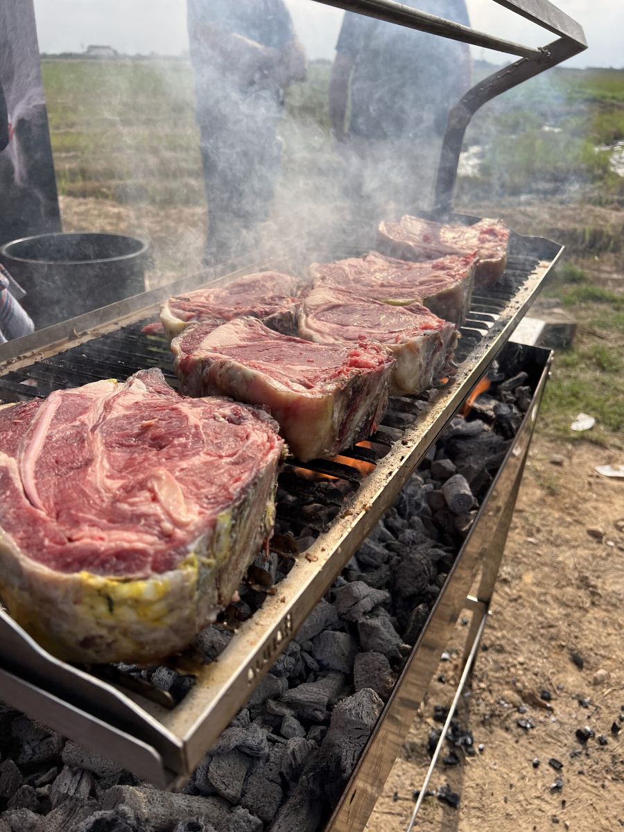 Chuletón a la brasa entre brasas de leña
