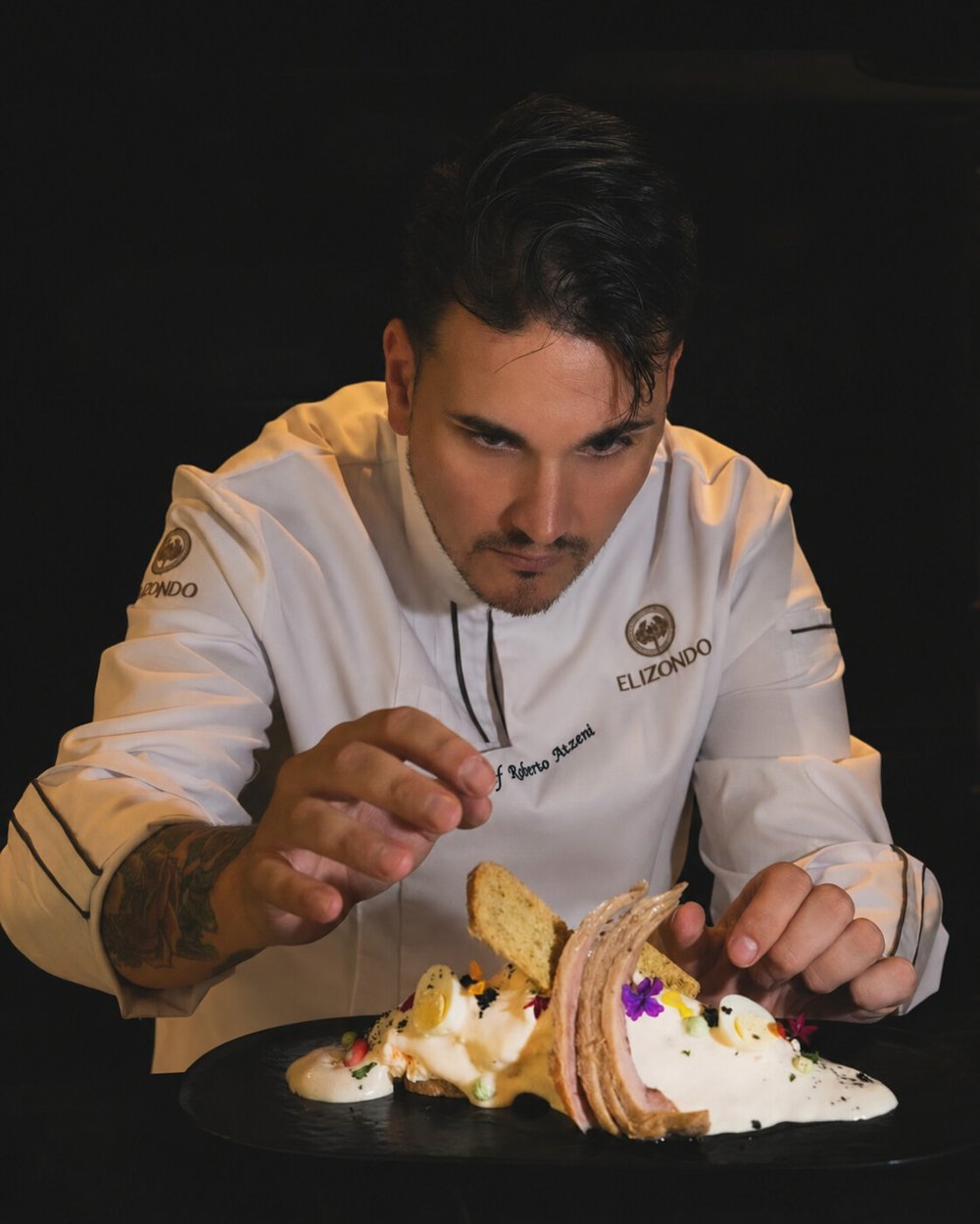 Roberto Atzeni emplatando con flor comestible